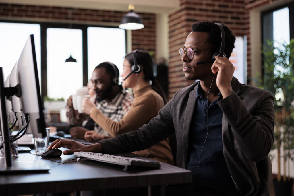 Three people in an office on calls